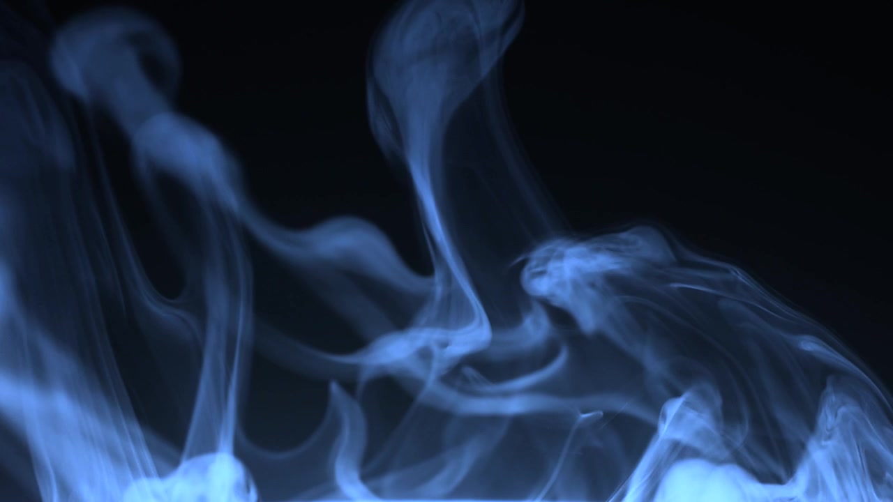 Fumo blu vorticoso in un ambiente scuro.