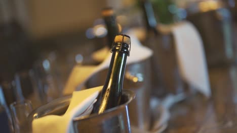 closed bottle of champagne in a metal container at the wedding banquet service