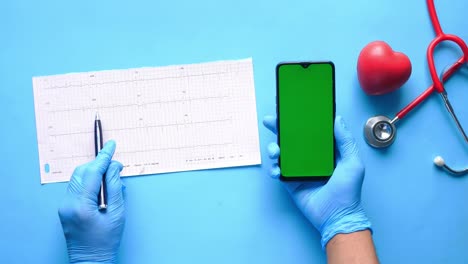 profesional médico que utiliza el teléfono inteligente y el ecg