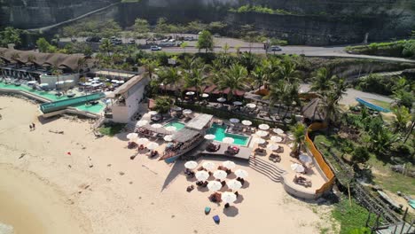 Minoo-and-Tropical-Temptation-Beach-Clubs-in-Melasti-Beach,-Uluwatu-Bali,-Indonesia---Aerial-Orbiting-Shot