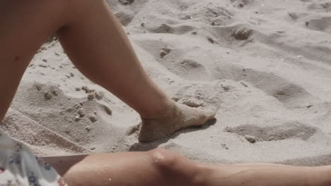 mujer atractiva acostada en una playa de arena con su novio de cerca. pareja disfrutando del verano.