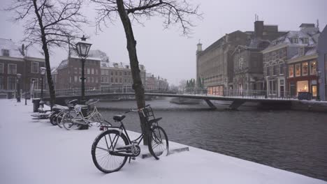 Leiden-city-centre-riverside-covered-in-snow,-quaint-Dutch-town-in-winter