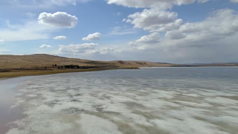 aerial view of a frozen lake with birds flying over