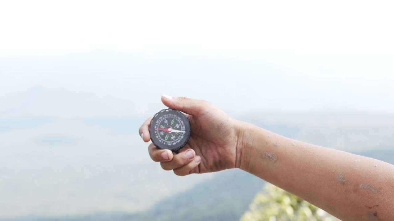 Hand holding a compass for travel.