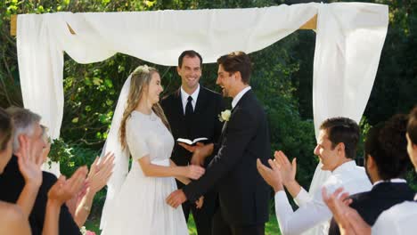 happy groom showing off wedding ring and happily kissing, hugging bride 4k 4k