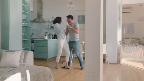 happy young couple dancing at home enjoying dance together having fun celebrating relationship