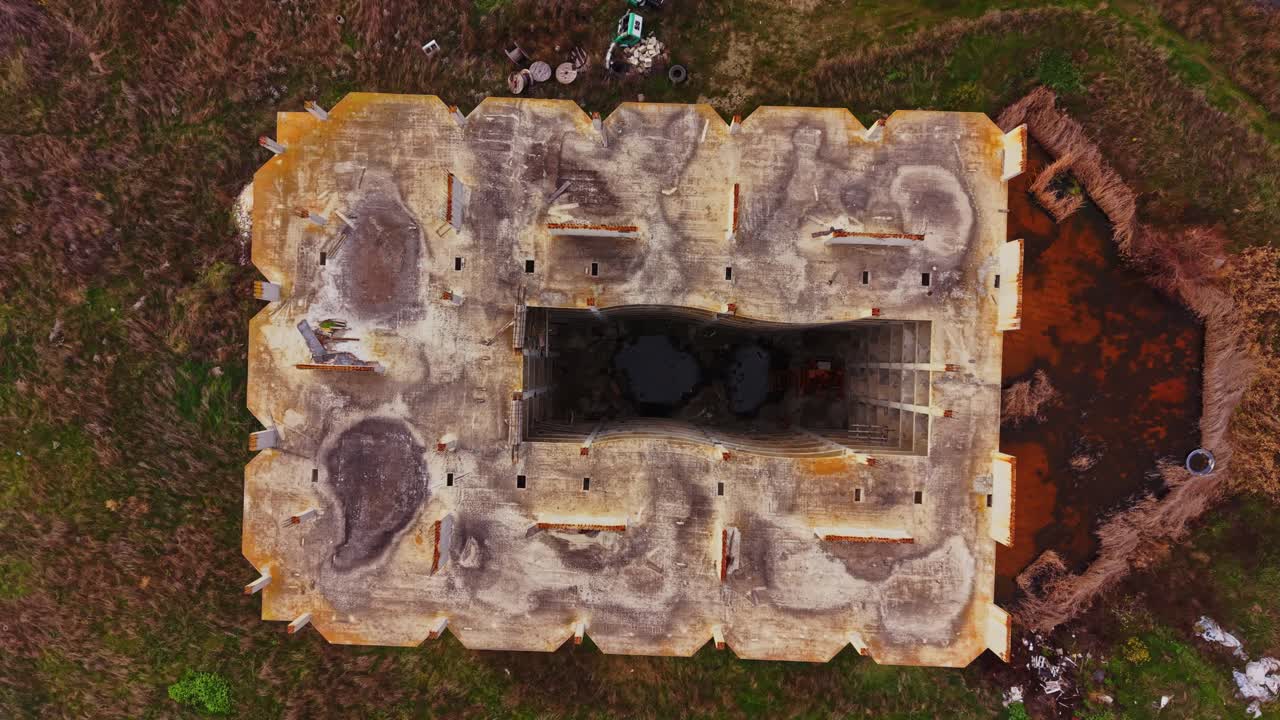 Aerial view of abandoned building surrounded by nature and debris