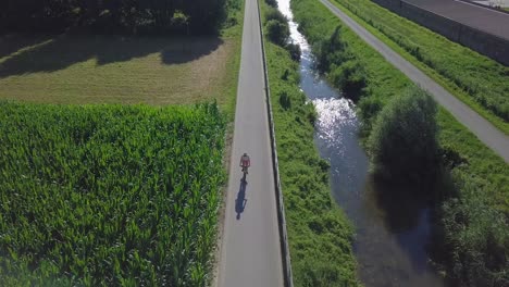 aerial panoramic view in sugana valley, italy with drone static and tilting down as biker rides