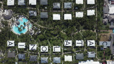 large letters adorn the roofs of the beautiful catalonia bavaro beach resort, aerial top down