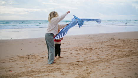 Padre-Lanzando-Cometa-De-Juguete-Con-Un-Niño-Pequeño-En-La-Playa.-Familia-Jugando-Juntos