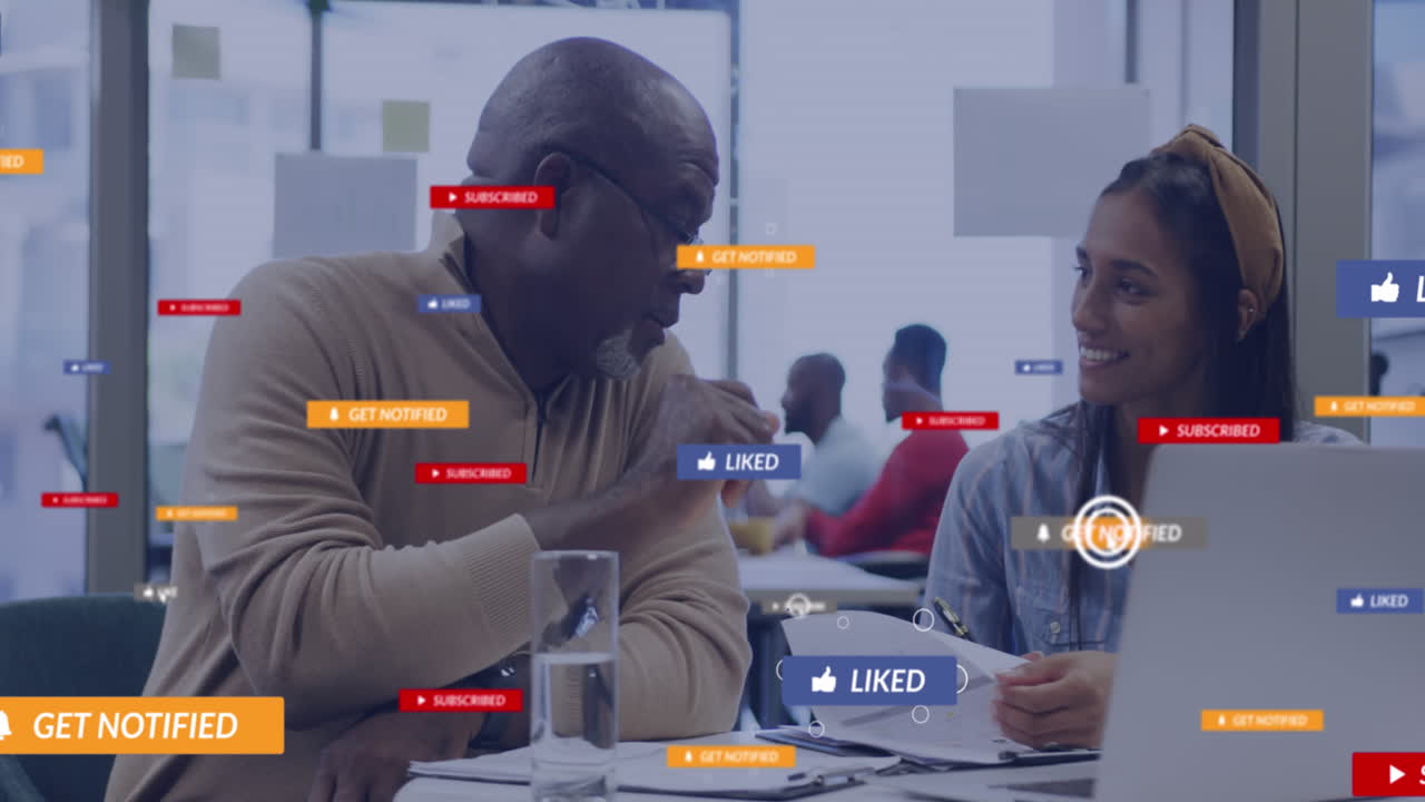 A group of diverse business colleagues talking and using laptops in an office