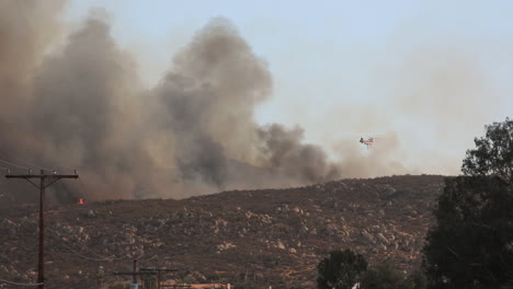 Helikopter-Wirft-Eine-Riesige-Ladung-Wasser-In-Das-Fairview-Feuer,-Während-Rauchwolken-Die-Sicht-Versperren