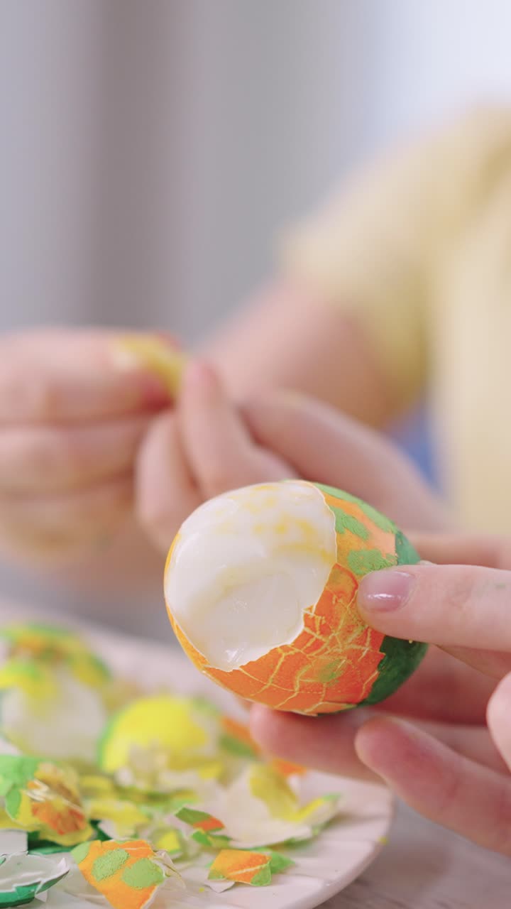 Close-up of Hands Peeling a Colorful Easter Egg