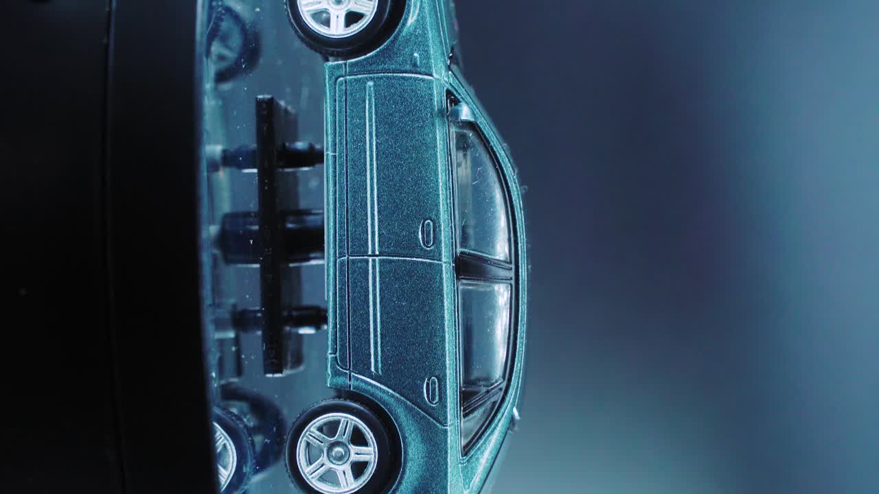 스튜디오 조명, 세로 클로즈업 샷, 4k 비디오, 은색 바퀴, 검은색 타이어, 문 및 창문이 있는 회전 스탠드에 있는 작은 모형 금속 샘플 자동차