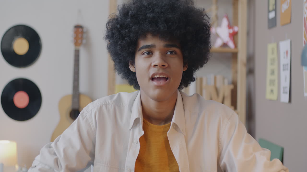 Teenager dancing and smiling in his room