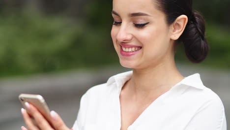 Mujer-De-Primer-Plano-Navegando-Por-Internet-En-Un-Teléfono-Inteligente.-Chica-Usando-Teléfono-Móvil-Al-Aire-Libre