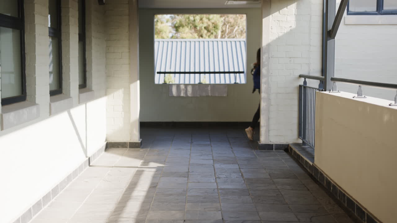 Sunlight streaming through windows in school corridor, creating peaceful atmosphere, copy space