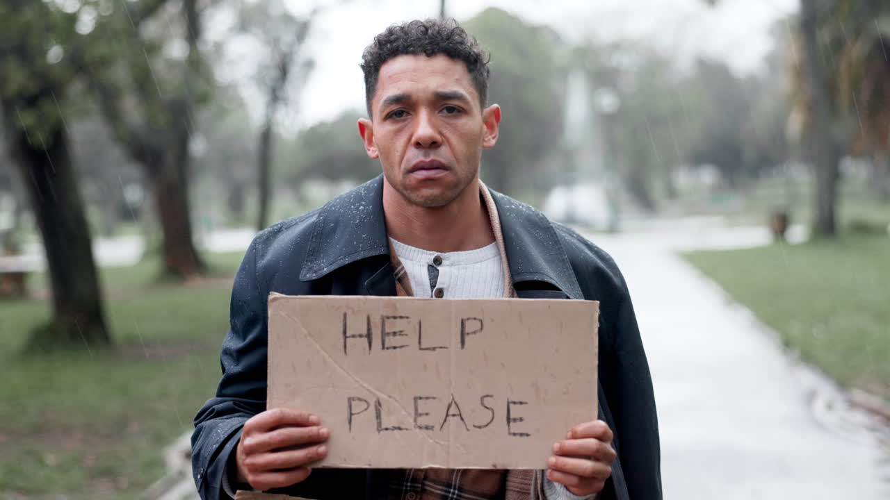 hombre sin hogar pidiendo ayuda en la lluvia