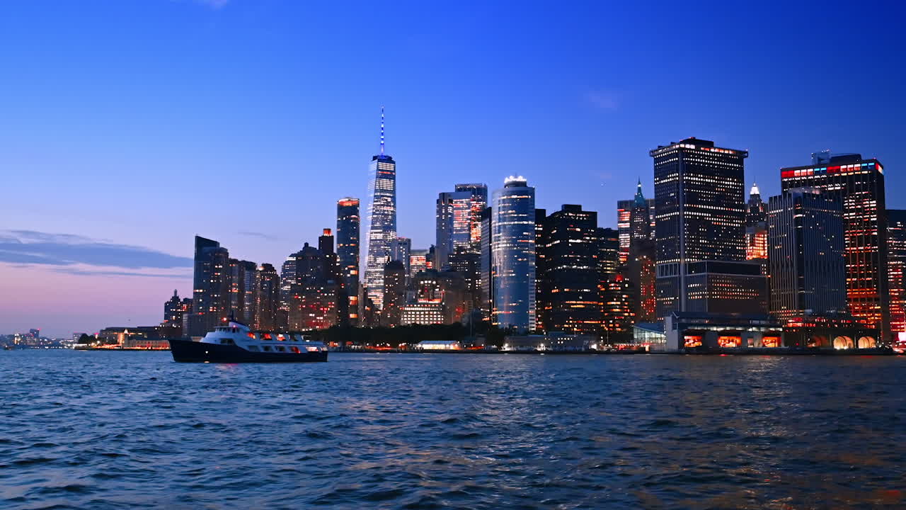 Imbarcazione che naviga in un paesaggio acquatico frastagliato al crepuscolo. Spettacolare skyline di New York sullo sfondo