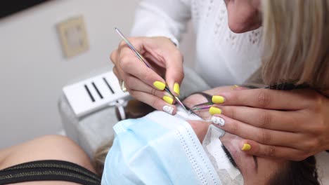 esteticista de cultivos aplicando pestañas en la cara de la mujer