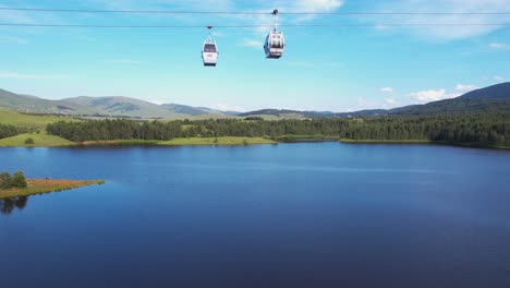 Drone Shot of Gold Gondola Cable Car Lift Above Lake in Landscape of Zlatibor Mountain, Serbia