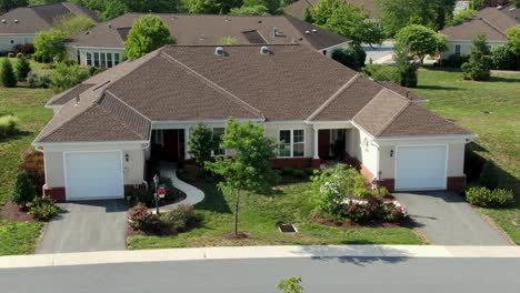 aerial push-in shot of modern single-story duplex house, apartment in senior living community in united states, american 55 plus retirement, independent living for retirees, front facade with garages