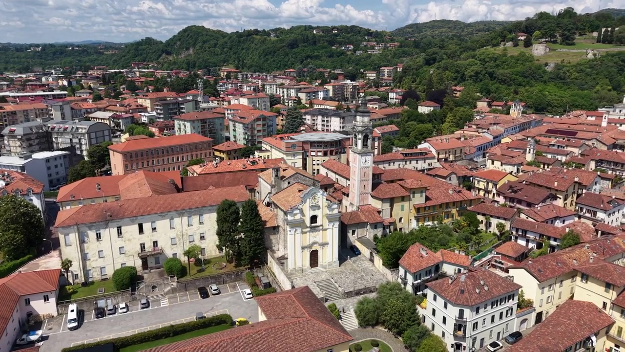 Ripresa aerea orbitale attorno alla Chiesa dei Santi Martiri e al campanile ad Arona, Italia