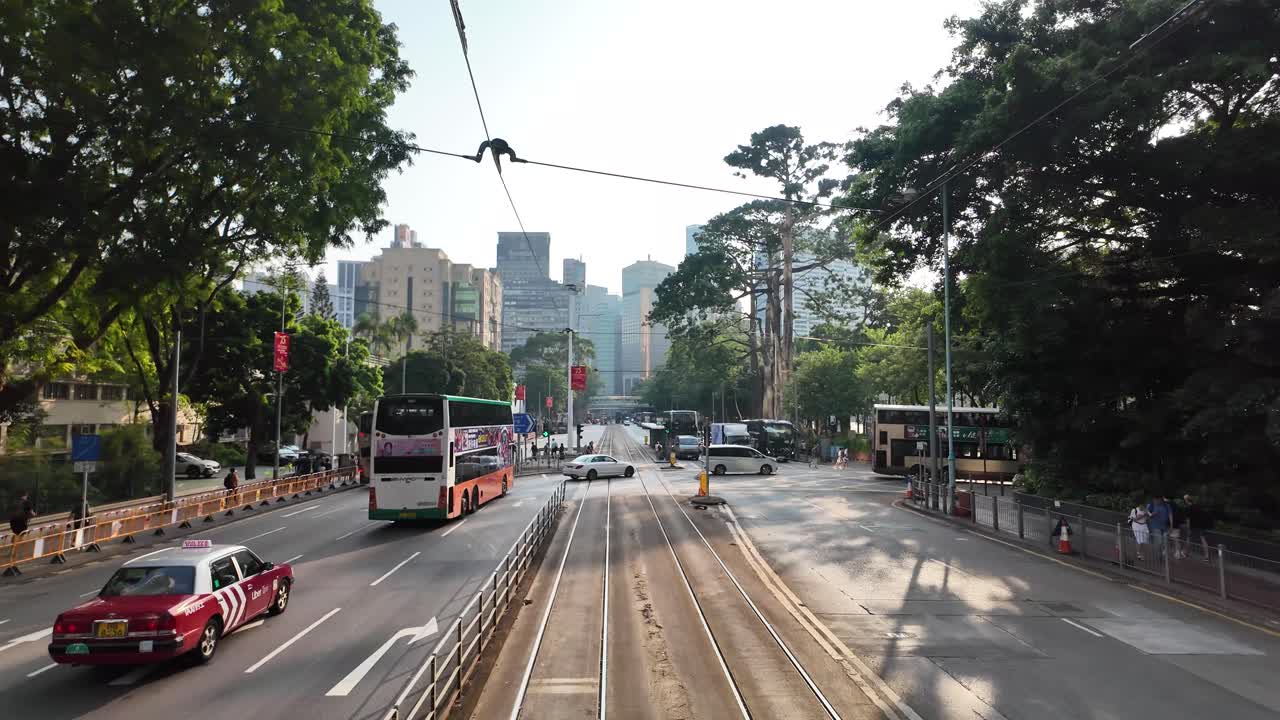 POV view from a tram traveling across North Point on King's Road in Hong Kong during the daytime. The bustling city showcasing urban life and public transportation.
