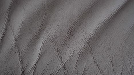 a white and dirty leather sofa. old leather sofa. wrinkles in the leather of the sofa