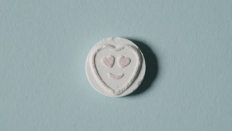 caramelo de corazón con amor emoji sobre fondo azul