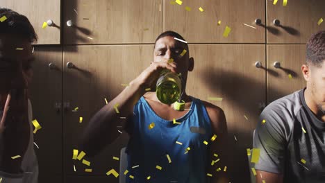 Golden-confetti-falling-against-male-soccer-player-drinking-water-sitting-in-changing-room