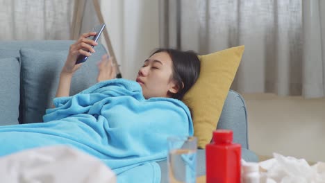 sick woman relaxing on couch with phone