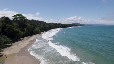 aerial view of tropical punta uva beach scene featuring a lush green forest lining the shoreline, gentle blue ocean waves