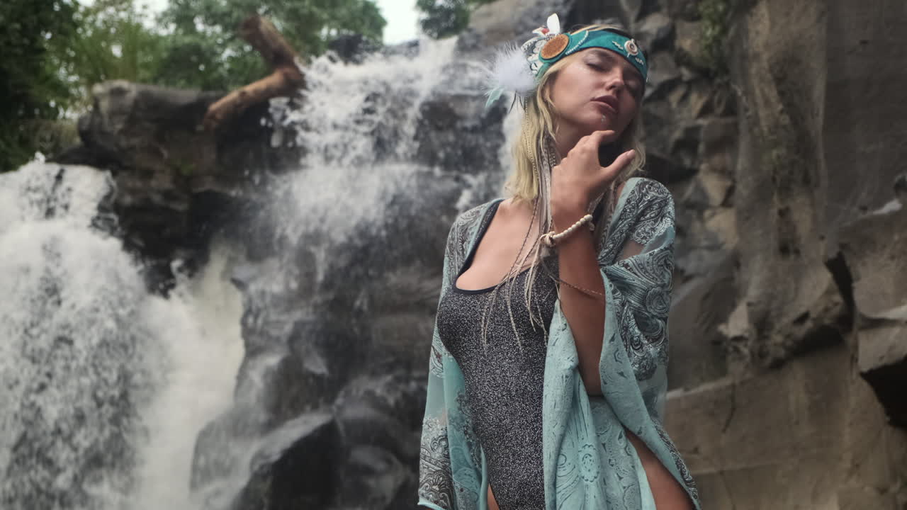 mujer en traje boho por la cascada