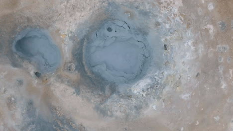 top down aerial view of mud pots in geothermal area of iceland, high angle drone shot