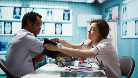 physician doing a medical consultation with blood pressure monitor