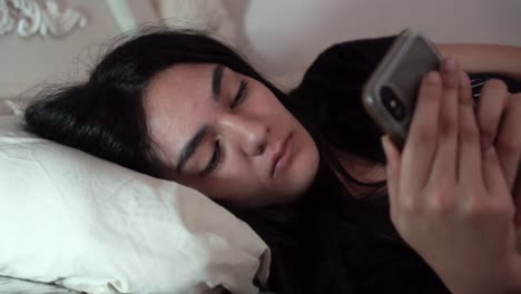 Chica-Enviando-Mensajes-De-Texto-En-Su-Teléfono-En-La-Cama