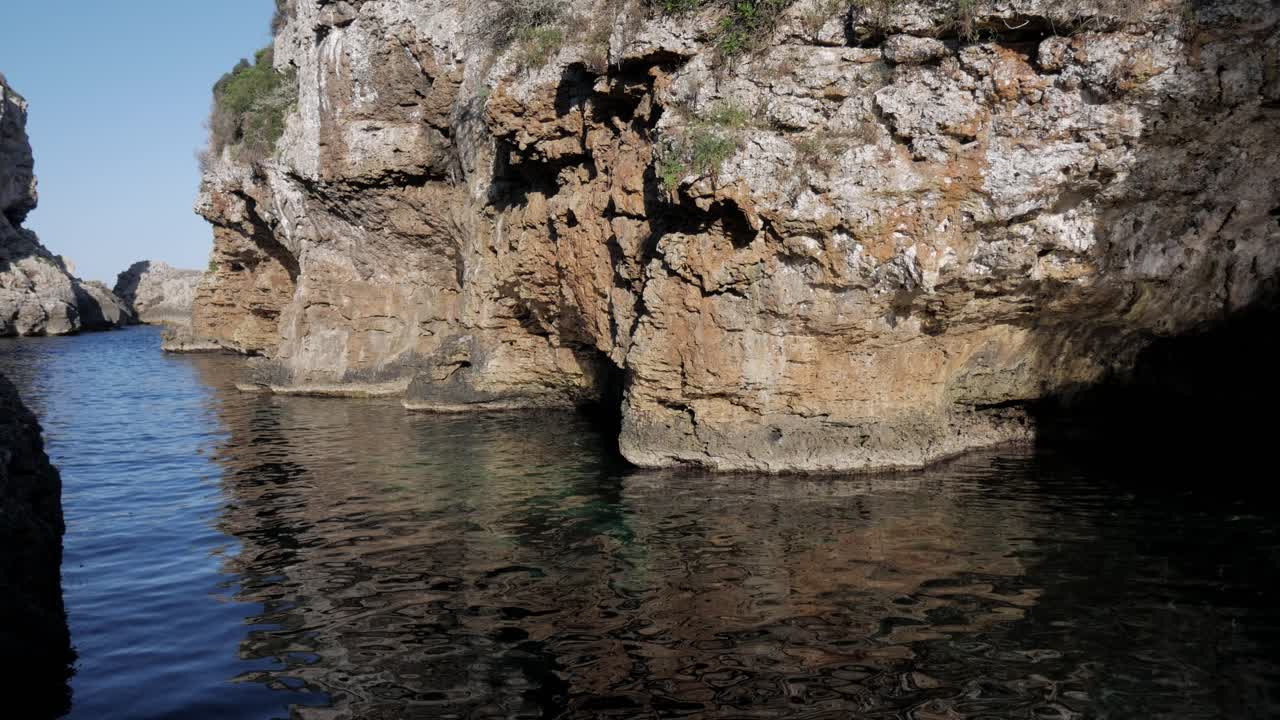 Rocky coastal inlet with clear blue water at Cala Rafalet, Baleares, Spain