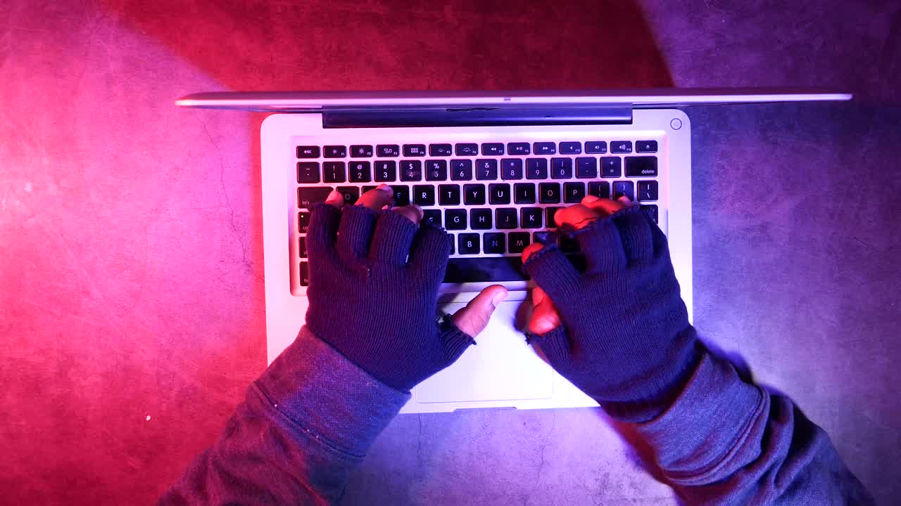 persona escribiendo en una computadora portátil con guantes