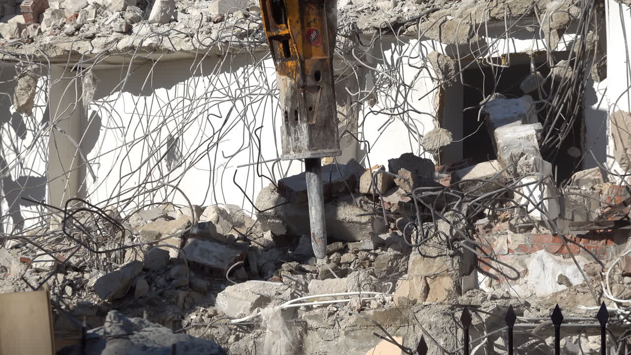 Chisinau, Moldova - June 6, 2025: An excavator demolishing concrete building with hydraulic breaker