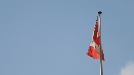 Kanadische-Flagge-Weht-Im-Wind-An-Einem-Klaren-Blauen-Himmel---Zeitlupe