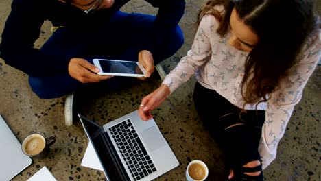 hombres y mujeres ejecutivos trabajando en computadoras portátiles