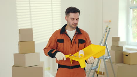 painter holding paint roller in a new house