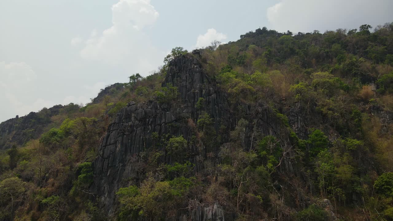 dolly aéreo de 4k, vista espectacular de la formación de roca caliza en el acantilado en un terreno accidentado en las montañas durante una temporada de verano en el sudeste asiático de tailandia