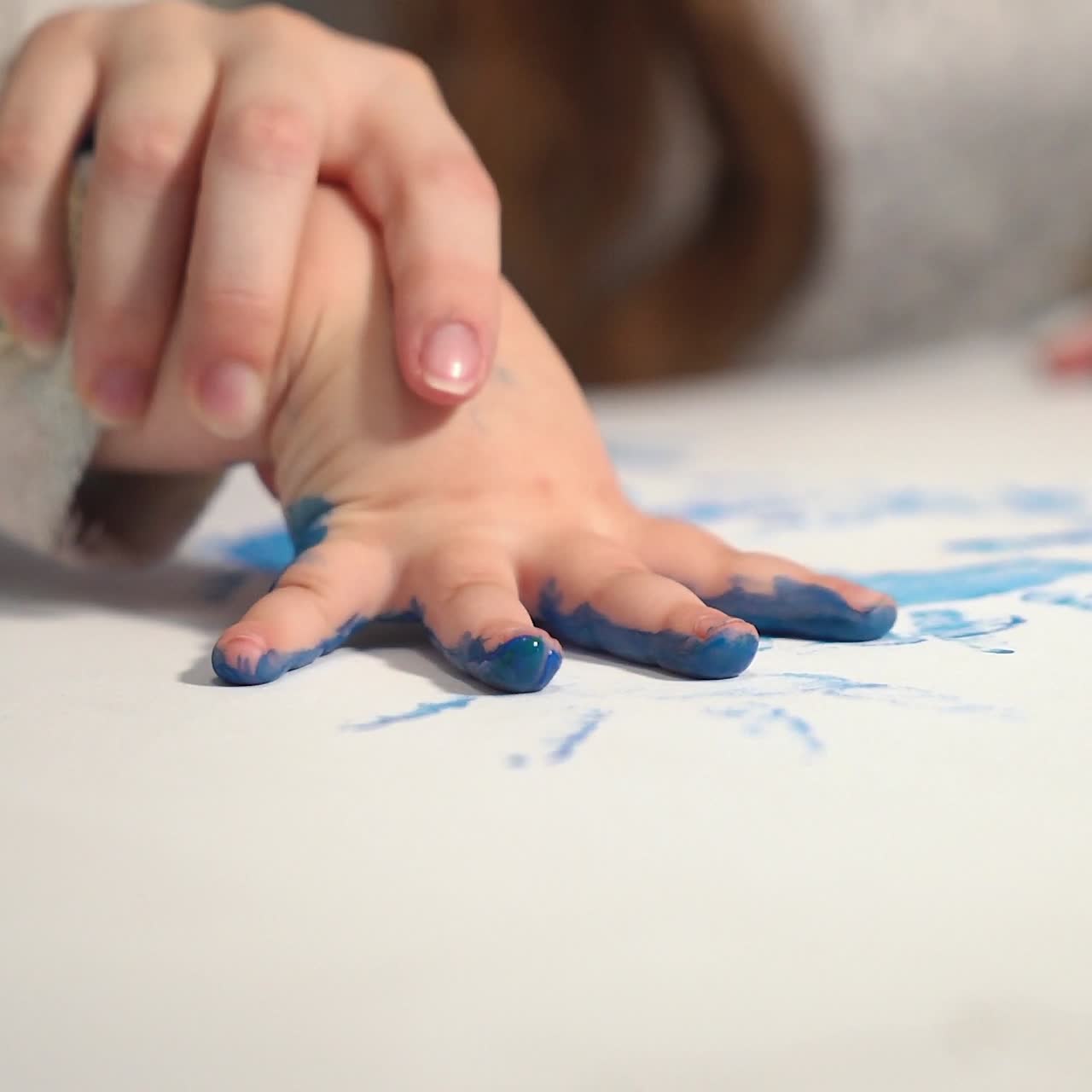 Imprint of children's hands made with paint. Child making hand prints on paper