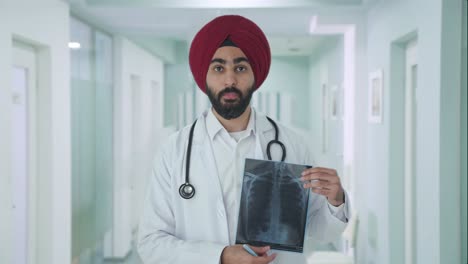 serious sikh indian doctor explaining x ray report to patient