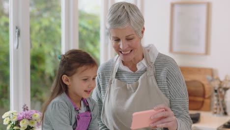 Abuela-Y-Niño-Usando-Un-Teléfono-Inteligente-Teniendo-Video-Chat-Niña-Compartiendo-El-Fin-De-Semana-De-Vacaciones-Con-La-Abuela-Disfrutando-Charlando-Por-Teléfono-Móvil-En-Casa-Con-Su-Nieta