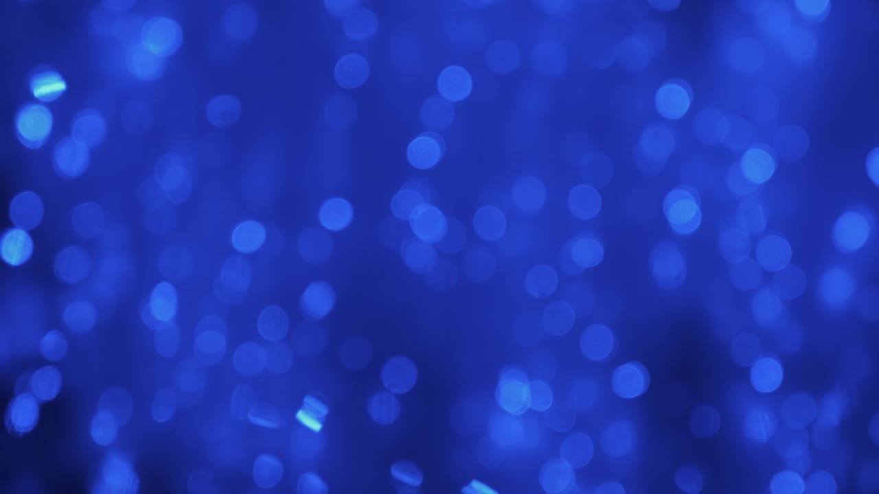 Movimento magico di luci blu sfocate. Gocce di pioggia cadono nell'acqua