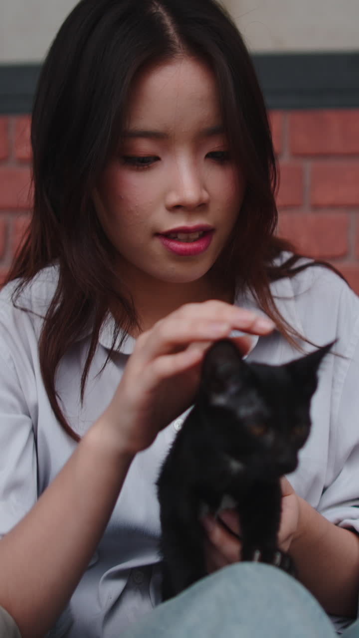 Woman holding a black cat