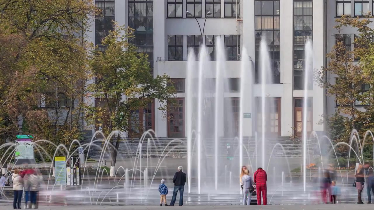 Edificio Gosprom en la Plaza de la Libertad con una nueva fuente seca y gente caminando en el parque en la ciudad de Járkov en timelapse, Ucrania. Vista de cerca